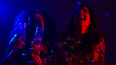 Nahaufnahme-Von-Zwei-Frauen-In-Einer-Nachtclubbar-Oder-Disco,-Die-Tanzen-Und-Alkohol-Mit-Papierkonfetti-Trinken